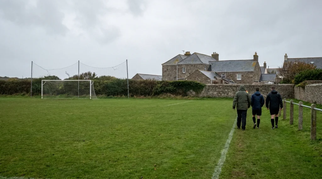 A well-maintained grass football pitch on a grey, blustery autumn afternoon in Jersey, Channel Islands.