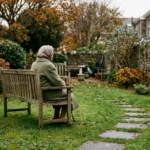 A quiet residential care home garden in Jersey, Channel Islands, on an overcast autumn afternoon — stone walls, mature shrubs