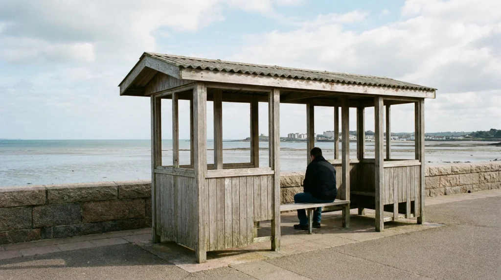 One of the existing promenade shelters along St Aubin's Bay on a clear day, seen from a slight angle to show its simple open-